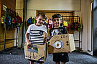 Zwei Jungen stehen in bemalten Pappkartons.