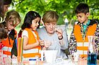 Bundeskanzlerin Angela Merkel forscht mit Kindern in Warnweste
