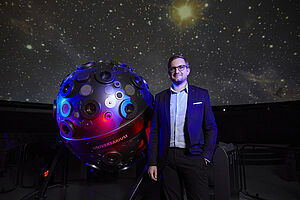 Tim Florian Horn steht vor einem großen Teleskop