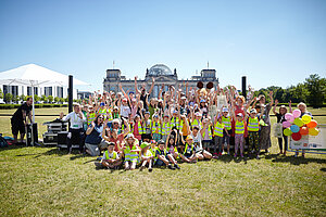 Gruppenfoto mit vielen Kindern auf der Wiese vorm Reichstag